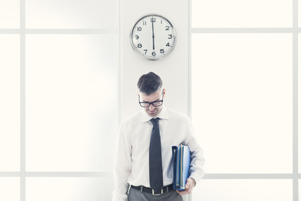 Frustrated businessman standing under a clock