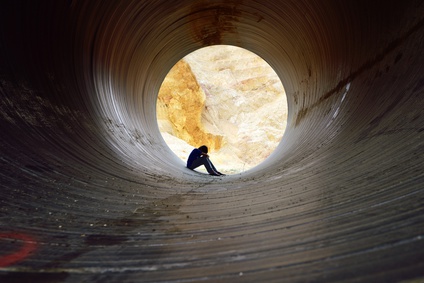 depressed young man sitting in the drain